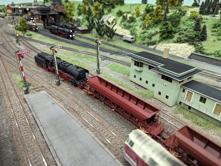 Eine Lok der Baureihe 44 schiebt einen Güterzug mit leeren Schüttgutwagen im Bahnhof Leinefelde.